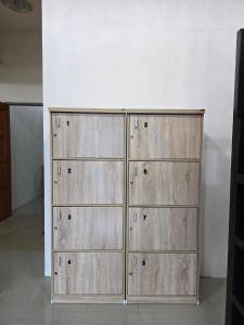 a set of four wooden storage cabinets in a room at Buddy Hostel in Chiang Rai