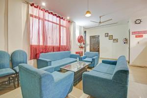 a waiting room with blue chairs and a table at Super Hotel O Glorious Stayz in Noida +18 photos