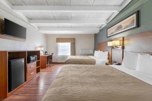 a hotel room with two beds and a television at Quality Inn & Suites Kansas City - Independence I-70 East in Independence +30 photos
