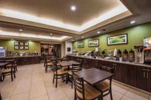 a restaurant with tables and chairs and a bar at Sleep Inn & Suites Tulsa Central I-44 in Tulsa