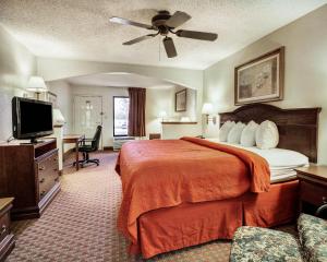 a hotel room with a bed and a flat screen tv at Quality Inn & Suites Clinton - Jackson West in Clinton