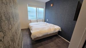a small bedroom with a bed and a window at ガジュマル House in Tonosho +10 photos