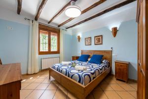 a bedroom with a bed with blue walls at Casa Rural Cortijo Celdran in Vélez-Rubio +24 photos