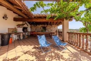 an outdoor patio with two blue chairs and a table at Casa Rural Cortijo Celdran in Vélez-Rubio