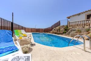 a swimming pool with a table and chairs next to it at Casa Rural Cortijo Celdran in Vélez-Rubio