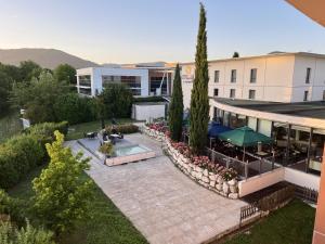 an overhead view of a building with a patio and a pool at Hôtel Le Palladior Voiron in Voiron