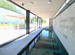 a swimming pool in a house with glass doors at Architect-Designed Villa with Heated Indoor Pool in Oslip