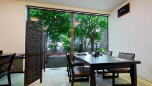 a dining room with a table and chairs and a large window at Shinwaso Kaishin in Amakusa