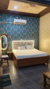 a bedroom with a bed and a blue wall at Rao sahab hotel and restaurant in Etah