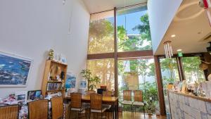 a room with a table and chairs and a large window at Shinwaso Kaishin in Amakusa