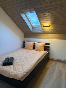 a bedroom with a large bed with a skylight at Csodaszarvas Erdeiház in Borzont