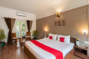 a bedroom with a large white bed with red sheets at Velvet Resort Khandala in Khandāla +24 photos