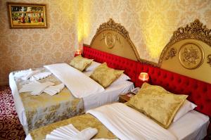 two beds in a room with red and yellow wallpaper at Balin Hotel - Special Category in Istanbul