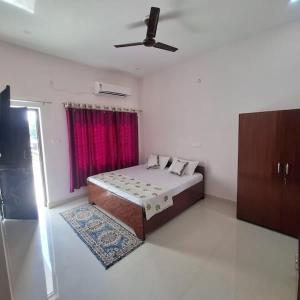 a bedroom with a bed and a red window at Hotel Ashish in Kaohni