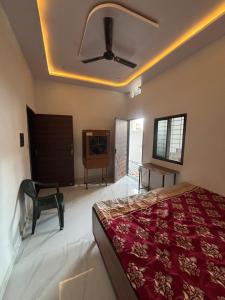 a bedroom with a bed and a ceiling fan at Hotel Ashish in Kaohni