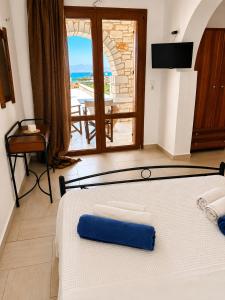 a bedroom with a bed with a view of the ocean at Avgerinos Village in Agiassos