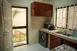 a kitchen with a sink and a washing machine at Appart Congo- Brazza - Av de la paix in Brazzaville