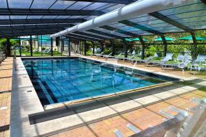 a large swimming pool with chairs at Hotel Benessere Villa Fiorita in Colfiorito