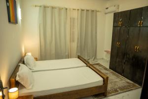 two beds in a small room with a shower at Appart Congo- Brazza - Av de la paix in Brazzaville