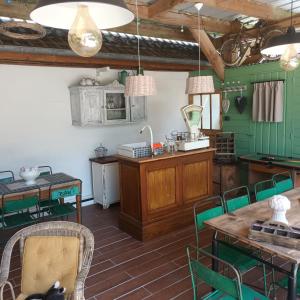a kitchen with green walls and a table and chairs at Le clos d'oli in Wamin