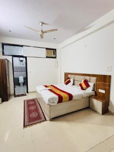 a bedroom with a bed and a ceiling fan at ADA Residency in Noida