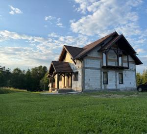 a small house in a field with a green yard at Csodaszarvas Erdeiház in Borzont
