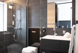 a bathroom with a shower and a toilet and a sink at EI Hotel by WMM Hotels in Eichstätt
