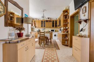 a kitchen with wooden cabinets and a table and chairs at Swimming Pool - Valley View Home Drobonik in Drobonik