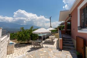 a patio with a table and chairs and an umbrella at Swimming Pool - Valley View Home Drobonik in Drobonik