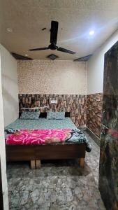 a bedroom with a bed with a ceiling fan at Radha rani sadan in Vrindāvan