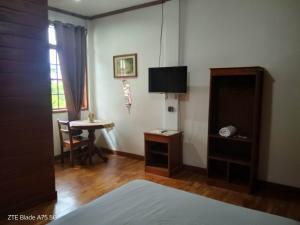 a room with a bed and a table and a television at REKWOOD Hotel in Boracay