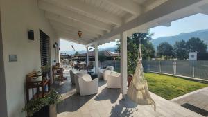 a porch with white chairs and a view of a yard at Bobbio Relax in Bobbio
