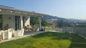 a patio with a table and chairs and a lawn at Bobbio Relax in Bobbio