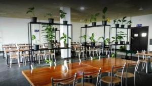 a dining room with a table and chairs with plants at Hotel Aam Bagh & Jain Shikanji in Kot Pūtli