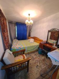 a bedroom with a bed and a table and a mirror at Квартира 89 in Bishkek
