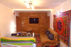a room with two beds and a couch and a tv at Квартира 89 in Bishkek +4 photos