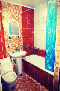 a bathroom with a toilet and a tub and a sink at Квартира 89 in Bishkek