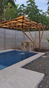 a wooden umbrella sitting over a swimming pool at Lions Houses in Parrita