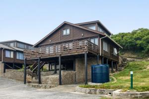 a house on a hill with a trash can in front of it at Beach Cabin with a pool in Port Alfred