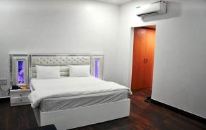 a bedroom with a white bed and a red door at Hotel Aam Bagh & Jain Shikanji in Kot Pūtli