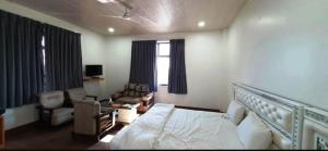 a bedroom with a bed and a living room at Hotel Aam Bagh & Jain Shikanji in Kot Pūtli