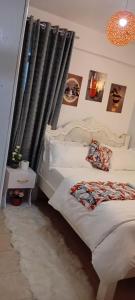 una camera da letto con un letto bianco e tende nere di The Amber Homes a Meru Altre 9 foto