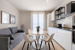 a living room with a couch and a table and chairs at Brezza Apartments in Santa Flavia