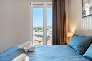 a bedroom with a blue bed and a window at Brezza Apartments in Santa Flavia