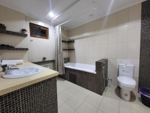 a bathroom with a sink and a toilet and a tub at CryptoHotel Park in Almaty