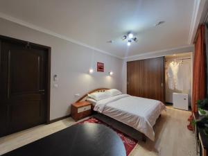 a bedroom with a bed and a black door at CryptoHotel Park in Almaty