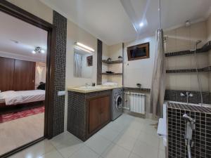 a bathroom with a sink and a washing machine at CryptoHotel Park in Almaty