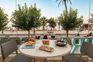 a table with two glasses of wine and food at Calipolis in Sitges