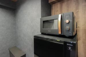 a microwave sitting on top of a black cabinet at INNEST Hakata in Fukuoka