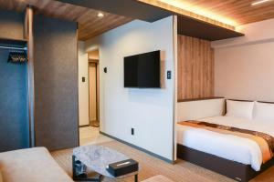 a hotel room with a bed and a flat screen tv at INNEST Hakata in Fukuoka